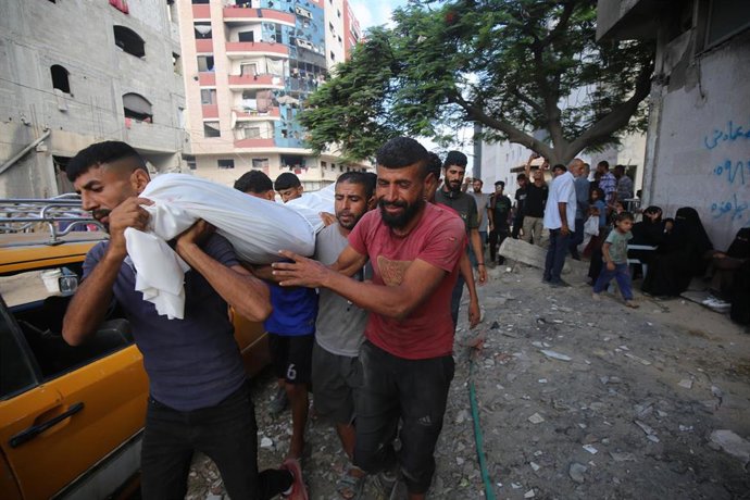 Palestinos trasladan el cadáver de una persona muerta en un ataque del Ejército de Israel durante un reparto de ayuda en la ciudad de Gaza, en el norte de la Franja de Gaza (archivo)