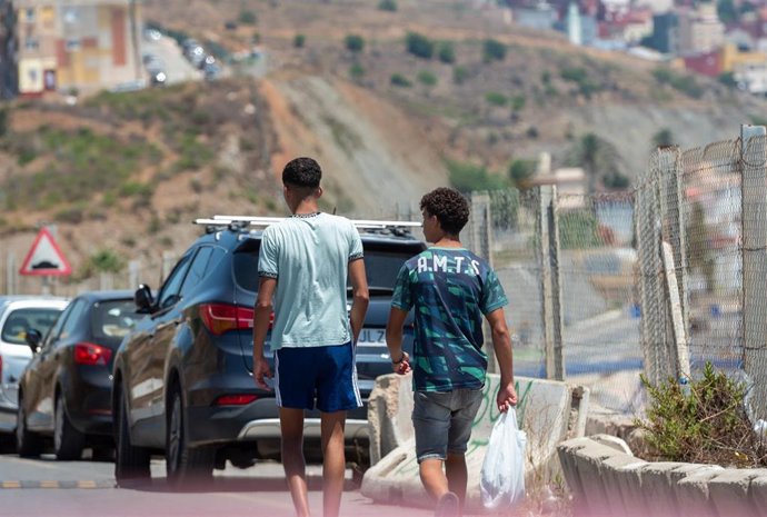 Dos jóvenes migrantes pasean por la calle en Ceuta.