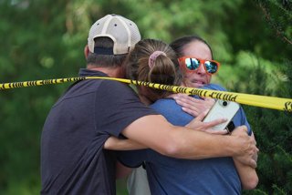 27 August 2025, US, Minneapolis: Community members embrace after shooting at Annunciation Church. Two children were killed and 17 other people were injured in a shooting during a church service at a Catholic school, police chief Brian O'Hara said on Wedne