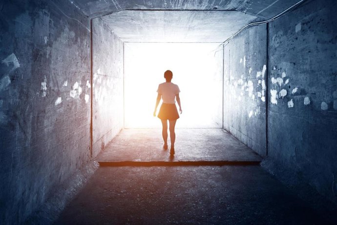 Archivo - Mujer atravesando un túnel de luz.