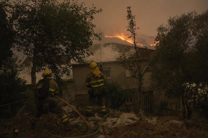Varios bomberos forestales tratan de extinguir un fuego en la provincia de Ourense, a 17 de agosto de 2025.
