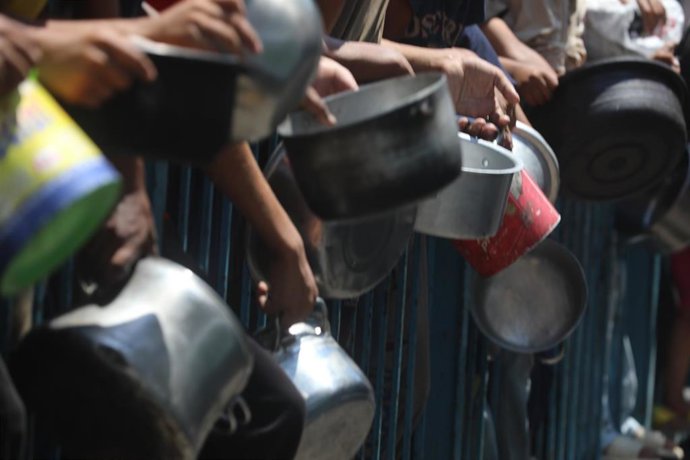 Palestinos esperan en la ciudad de Gaza para recibir alimentos de una organización caritativa ante la hambruna registrada a causa de la ofensiva de Israel y las restricciones israelíes a la entrada de ayuda humanitaria en la Franja (archivo)