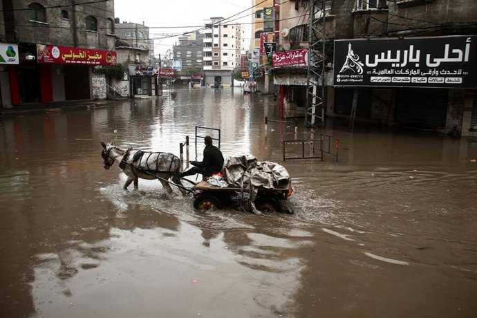 Archivo - Imagen de archivo de un hombre atravesando una calle anegada por las lluvias torrenciales en Pakistán.
