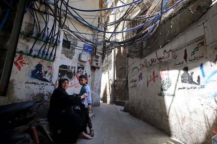 Archivo - Arquivo - 18 de junho de 2025, Beirute, Beirute, Líbano: Uma mulher palestina descansa com seu filho em um beco estreito dentro do campo de refugiados de Burj al-Barajneh, em Beirute, na véspera do Dia Mundial do Refugiado das Nações Unidas, em 