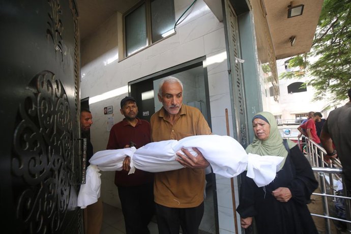 13 de agosto de 2025, Cidade de Gaza, Faixa de Gaza, Território Palestino: Parentes dos palestinos que morreram em decorrência dos ataques israelenses aos bairros de Zeytun e Shujaiya choram enquanto os corpos são levados do Hospital Al-Shifa para serem e