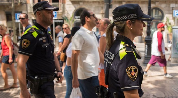 Agentes de la Guardia Urbana patrullan por las calles de Barcelona.