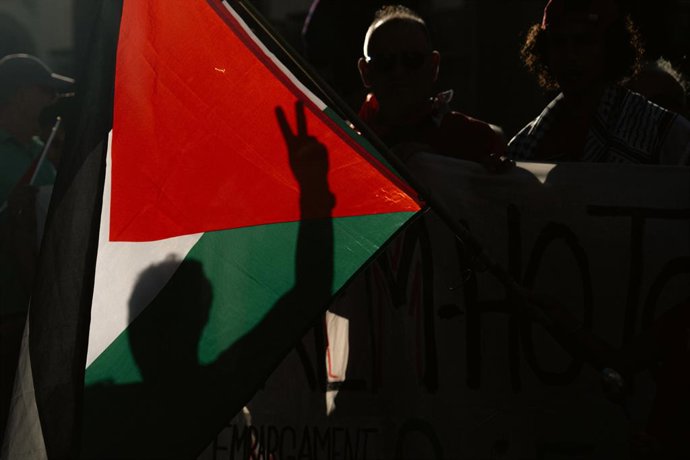 Varias personas con una bandera palestina durante una manifestación por la liberación de Palestina, a 9 de agosto de 2025, en Barcelona, Catalunya (España). La protesta está convocada por la organización internacional Moviment Global a Gaza y a la que se 