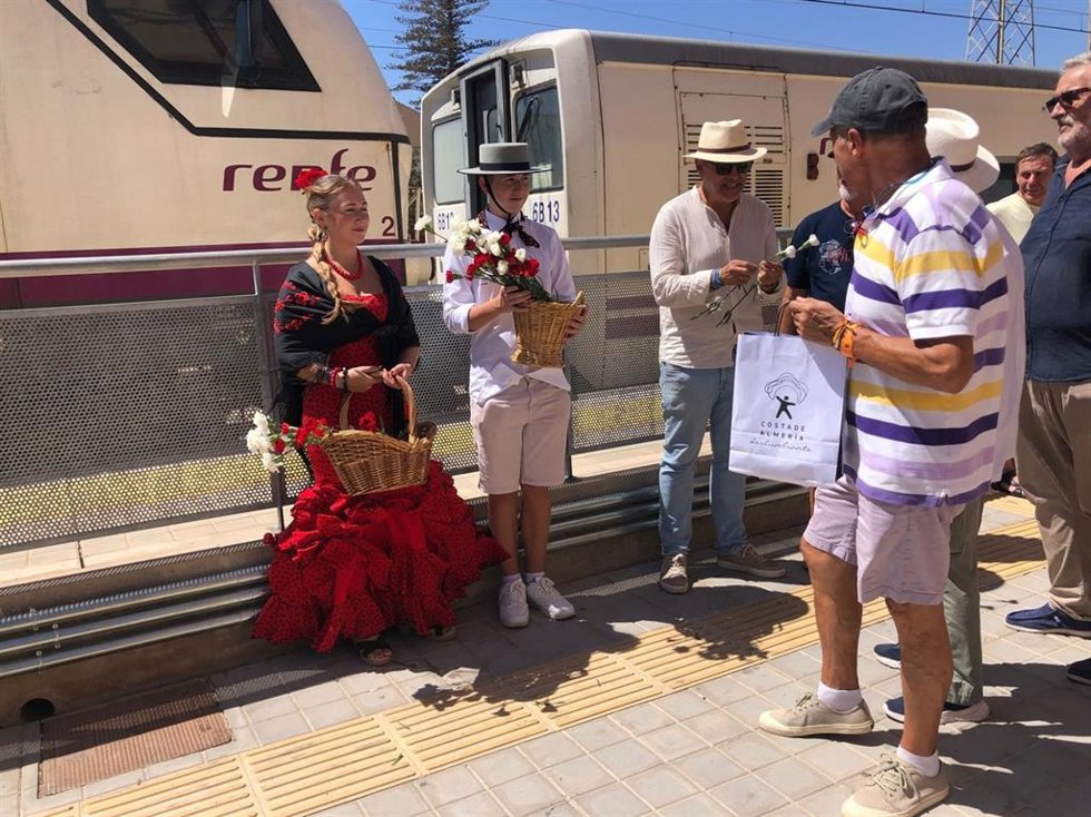 Los miembros de la Mesa en Defensa del Ferrocarril reparten flores y obsequios a los pasajeros procedentes de Madrid en la estación Huércal-Viator (Almería).