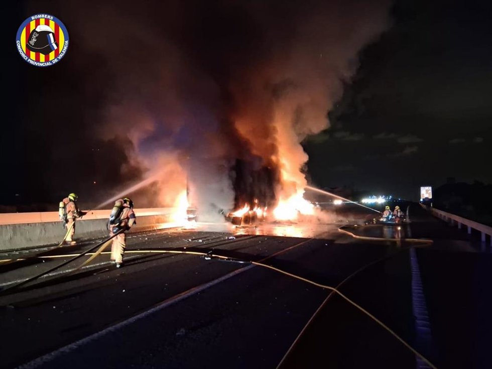 Efectivos del Consorcio provincial de Bomberos de Valencia sofocando el incendio registrado en la A7 a su paso por Puol tras arder un camión, chocar otro con él y producirse un nuevo fuego.