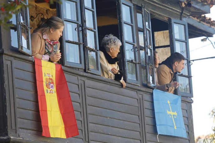 Archivo - Varias personas observan desde un balcón la visita de la Familia Real al ganador del Premio al Pueblo Ejemplar de Asturias 2023, a 21 de octubre de 2023, en Arroes, Villaviciosa.