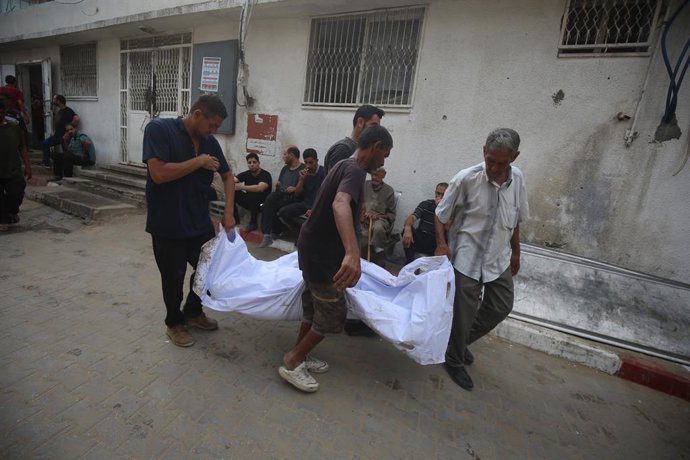13 de agosto de 2025, Cidade de Gaza, Faixa de Gaza, Território Palestino: Parentes dos palestinos que morreram em decorrência dos ataques israelenses aos bairros de Zeytun e Shujaiya choram enquanto os corpos são levados do Hospital Al-Shifa para serem e