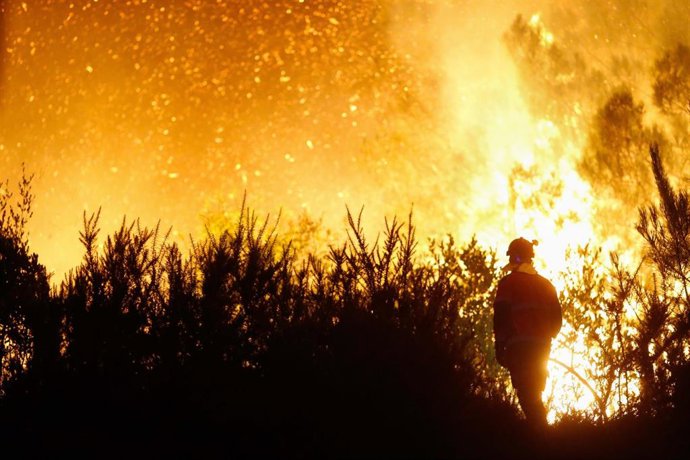 Un vecino ve el avance del fuego, a 25 de agosto de 2025, en A Pobra de Brollón, Lugo, Galicia (España). Un incendio en el municipio lucense de A Pobra do Brollón, originado en la parroquia de Abrence, ha obligado a declarar la situación 2 de emergencia. 