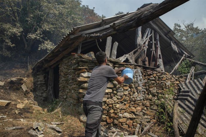 Ganadero propietario de algo más de cien vacas en Teixeira, intenta sofocar el fuego en uno de los refugios de los animales, a 10 de agosto de 2025, en Maceda, Ourense, Galicia (España). 