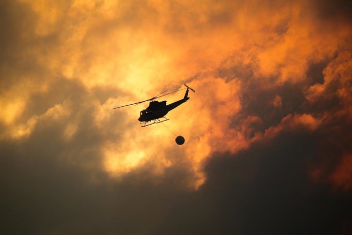Um helicóptero coleta água para ajudar a extinguir um incêndio, em 26 de agosto de 2025, em Aguas Mestas, Lugo, Galícia, Espanha. As condições parecem estar melhorando na província de Lugo, que foi particularmente atingida pela recente onda de incêndios f