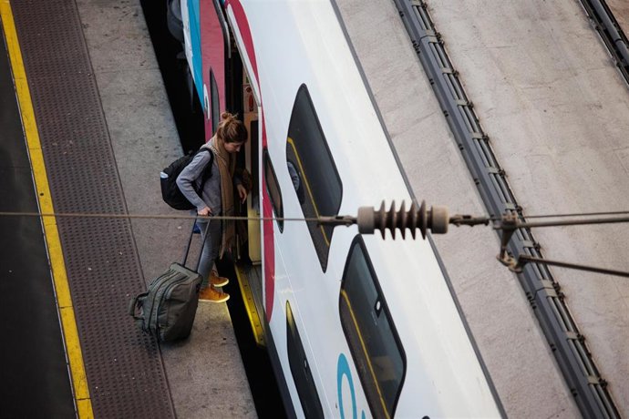 Archivo - Una mujer entra en el tren con su maleta. Imagen de archivo.