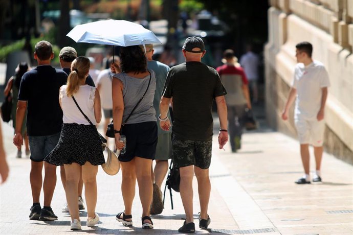 Viandantes soportan las altas temperaturas por las calles de Málaga.