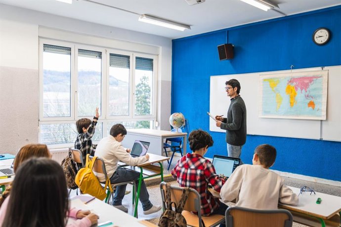 Profesor dando clase en un aula con alumnos.