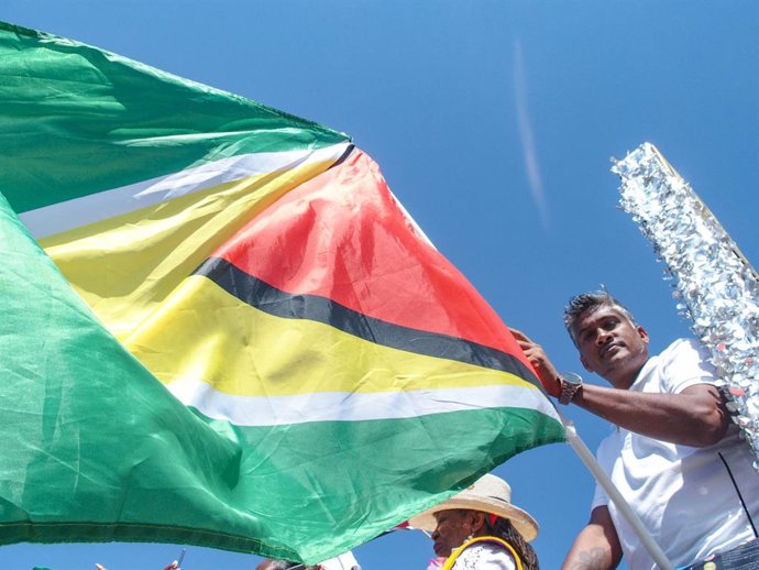 Archivo - Arquivo - Imagem de arquivo de um homem segurando uma bandeira da Guiana durante o feriado bancário.
