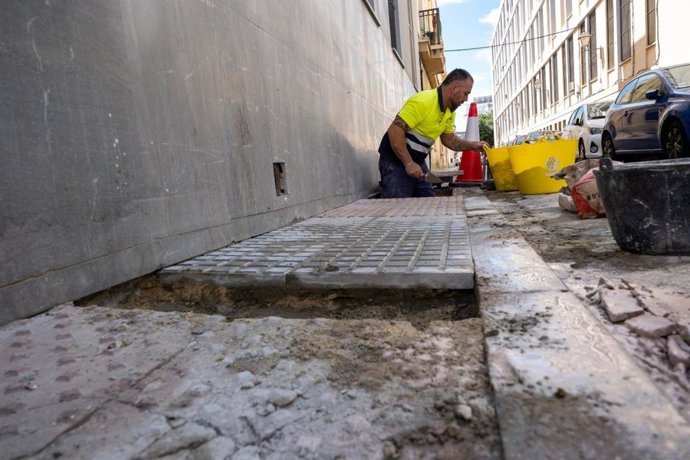 Trabajos de mantenimiento en un acerado en una calle de Cádiz.