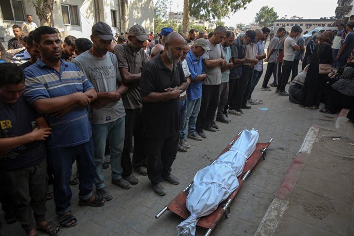 30 de agosto de 2025, Cidade de Gaza, Faixa de Gaza, Território Palestino: Pessoas rezam ao lado de corpos durante o funeral de palestinos que foram mortos por fogo israelense enquanto tentavam receber ajuda e outro morto em um ataque na sexta-feira, de a