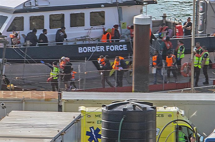 Archivo - Agentes de las patrullas fronterizas acompañan a migrantes rescatados en el canal de la Mancha y llegados al puerto de Dover, en Kent, Reino Unido