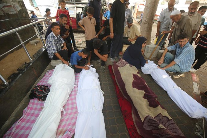 13 de agosto de 2025, Cidade de Gaza, Faixa de Gaza, Território Palestino: Parentes dos palestinos que morreram em decorrência dos ataques israelenses aos bairros de Zeytun e Shujaiya choram enquanto os corpos são levados do Hospital Al-Shifa para serem e