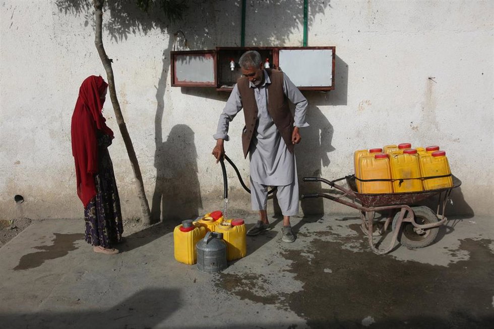 Archivo - Un hombre rellena una garrafa con agua en Kabul, Afganistán
