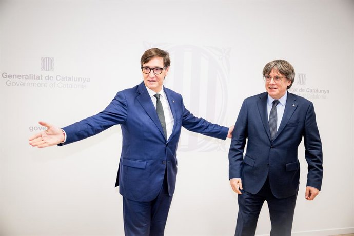 El presidente de la Generalitat, Salvador Illa (i), saluda al presidente de Junts per Catalunya, Carles Puigdemont (d), durante una reunión, a 2 de agosto de 2025, en Bruselas (Bélgica). Illa, quién ha promovido la reunión, ha remarcado su intención de te