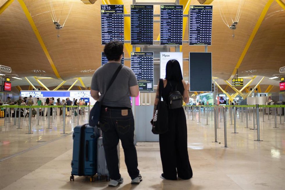Varias personas miran las pantallas informativas en la T4 del Aeropuerto Adolfo Suárez Madrid-Barajas, a 31 de agosto de 2025, en Madrid (España).