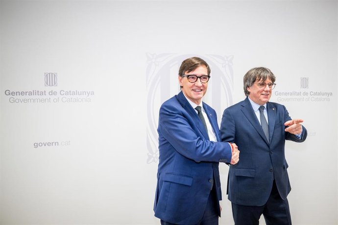 El presidente de la Generalitat, Salvador Illa (i), saluda al presidente de Junts per Catalunya, Carles Puigdemont (d), durante una reunión, a 2 de agosto de 2025, en Bruselas (Bélgica). Illa, quién ha promovido la reunión, ha remarcado su intención de te