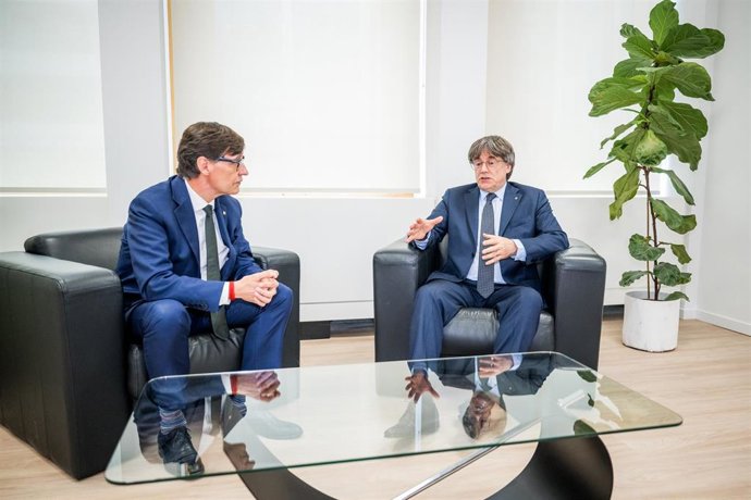 El presidente de la Generalitat, Salvador Illa (i), saluda al presidente de Junts per Catalunya, Carles Puigdemont (d), durante una reunión, a 2 de agosto de 2025, en Bruselas (Bélgica). Illa, quién ha promovido la reunión, ha remarcado su intención de te