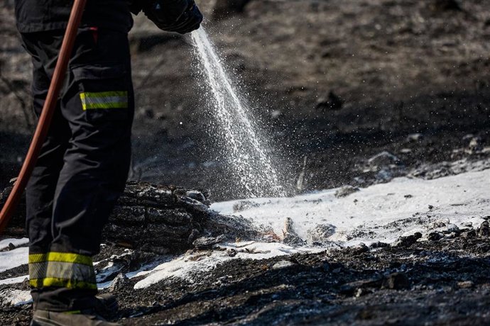 Un bombero de la Comunidad de Madrid sujeta una manguera para extinguir un incendio, a 19 de agosto de 2025, en Colmenar Viejo, Madrid (España).