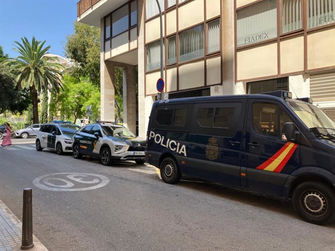 Agentes da Guardia Civil e da Polícia Nacional posicionados em frente a um prédio em Palma como parte de uma operação contra a lavagem de dinheiro.