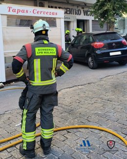 Un efectivo del Consorcio Provincial de Bomberos de la Diputación de Málaga interviene en el incendio en una cafetería en Ronda que se ha originado en una freidora.