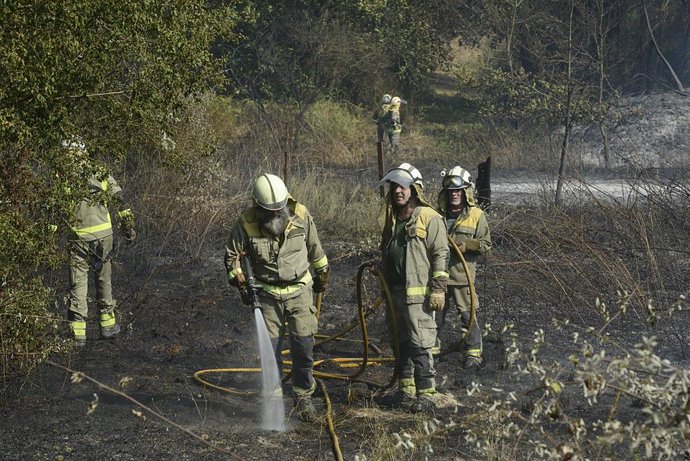 Archivo - Varios bomberos trabajan en la extinción de un incendio en Ourense