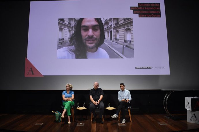 El director de 'Sirat' Oliver Laxe en pantalla, i els productors de la pel·lícula amb Agustín Almodóvar (centre) durant l'anunci dels  tres títols que opten a representar a Espanya en la propera edició dels Oscar, en l'Acadèmia de Cinema, a 3 de setembre