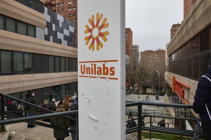 Archivo - Varias personas hacen cola en las inmediaciones de los Laboratorios Unilabs situados en la calle Juan Esplandiú para realizarse pruebas de detección del COVID-19, en Madrid (España), a 21 de diciembre de 2020.