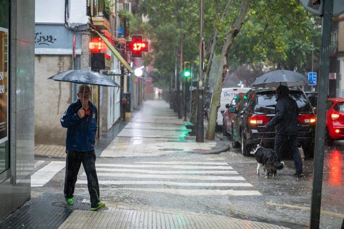 Archivo - Varias personas caminan bajo la lluvia, a 21 de septiembre de 2024, en Zaragoza, Aragón (España). 