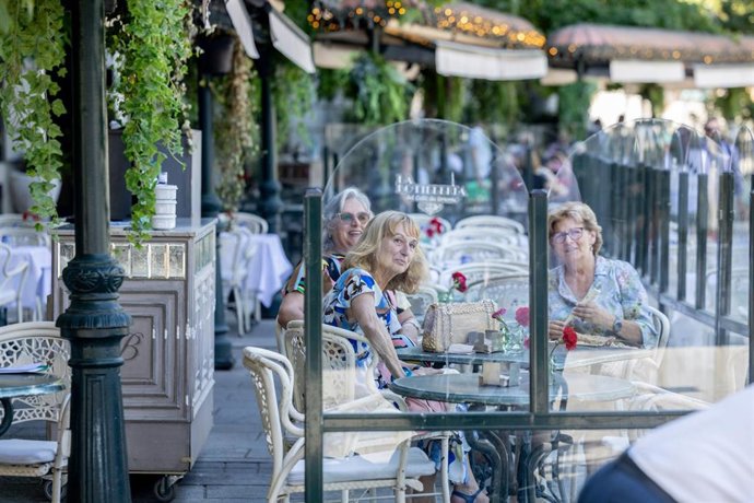 Archivo - Clientes de un bar se refrescan en la terraza, a 15 de julio de 2025, en Madrid (España).