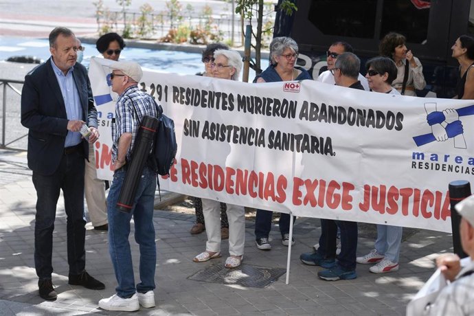 Archivo - El exconsejero de Políticas Sociales Alberto Reyero (i) conversa con un hombre que participa en una concentración para pedir justicia por los residentes fallecidos durante el Covid.