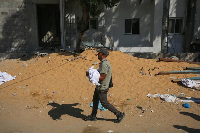 Archivo - 06 July 2025, Palestinian Territories, Gaza: A man holds the dead body of one of the Palestinians killed in Israeli airstrikes that targeted civilian homes in Gaza City, Gaza, killing over 20 Palestinians, including women and children. Photo: Om