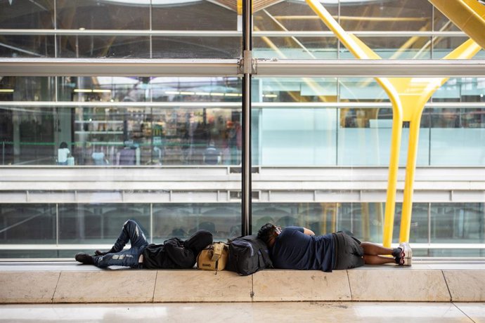 Várias pessoas deitadas no T4 do Aeroporto Adolfo Suárez Madrid-Barajas, em 31 de agosto de 2025, em Madri (Espanha). Os aeroportos da rede Aena têm 21.327 voos programados para este fim de semana, coincidindo com o retorno da temporada de férias.
