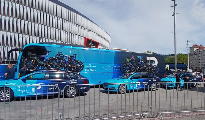 Autobús y coches del Israel Premier Tech estacionados ante el estadio de San Mamés, en Bilbao