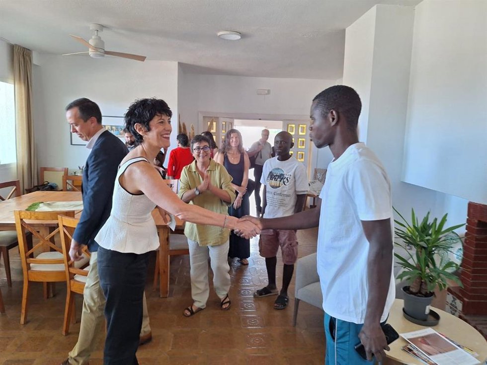 La ministra de Inclusión, Seguridad Social y Migraciones, Elma Saiz, saluda a uno de los residentes durante su visita a las viviendas de tuTECH en la pedanía de San Isidro, en Níjar (Almería).