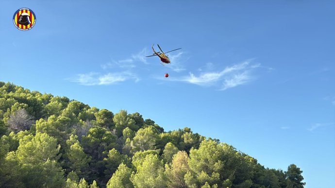 Helicóptero del Consorcio Provincial de Bomberos de Valencia trabajando en la extinción de un incendio de vegetación en Oliva.