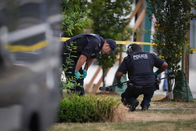 7 de agosto de 2025, Surrey, BC, CANADÁ: Policiais da RCMP procuram evidências do lado de fora de um café que foi alvo de tiros, em Surrey, BC, na quinta-feira, 7 de agosto de 2025. A polícia está investigando depois que tiros foram disparados pela segund