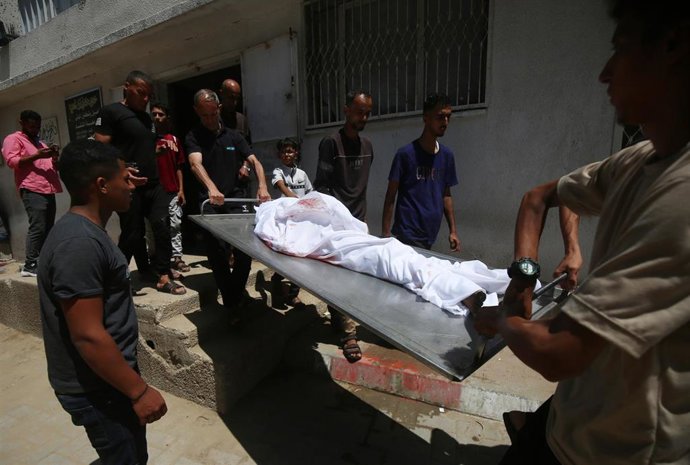 Archivo - Palestinos trasladan el cadáver de una persona muerta a causa de los ataques del Ejército de Israel contra la Franja de Gaza en el marco de su ofensiva tras los ataques del 7 de octubre de 2023 (archivo)