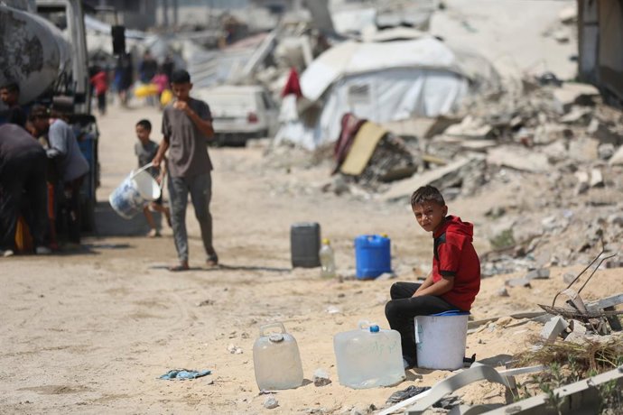 Archivo - 26 July 2025, Palestinian Territories, Gaza: Palestinian children try to meet their daily water needs by filling jerry cans from water tankers brought into the area in Gaza city, on July 26, 2025. In the Gaza Strip, which remains under Israeli a