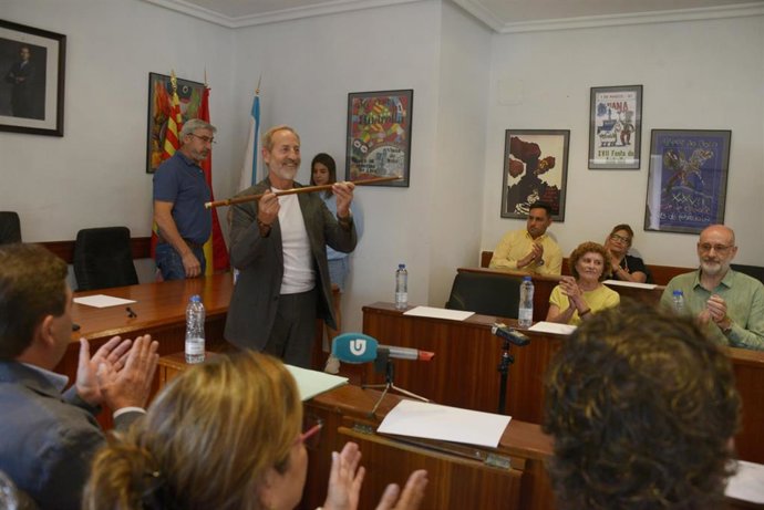 El alcalde entrante en Viana do Bolo, Germán Aurelio García Ávila, del PSdeG-PSOE (der.) tras recoger el bastón de mando municipal de manos del alcalde saliente, Andrés Montesinos del PP