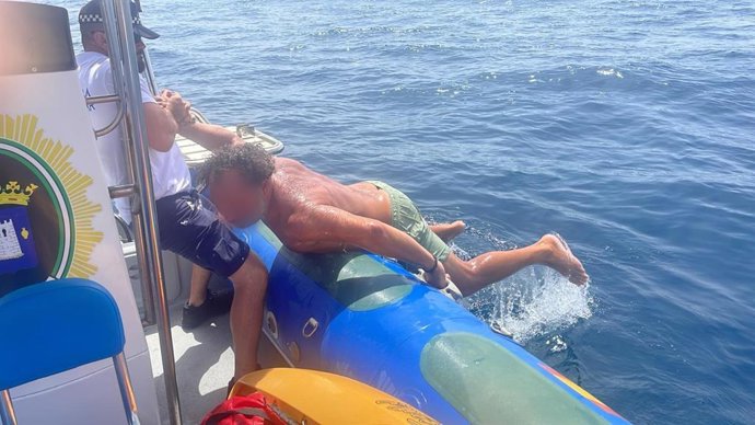 Un agente de la patrulla marítima de Níjar (Almería) auxilia a un hombre durante un rescate en la costa este verano.